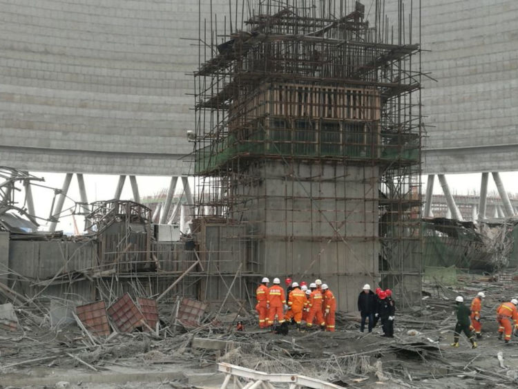 Rescue workers search the site of cooling tower collapse